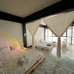 清迈FrenTé Chiang Mai的一间卧室配有一张床、一张沙发和窗户。