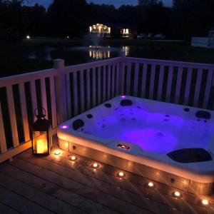 约克Juniper Lodge with Hot Tub的甲板上的按摩浴缸(晚上)