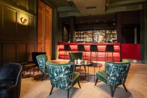 洛什Best Western Premier Hotel de la Cite Royale的一间带桌椅的餐厅和一间酒吧