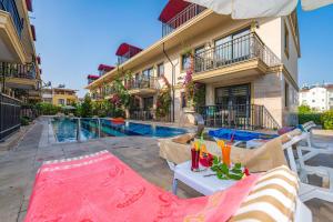 费特希耶Yaşam Park Residence - Fethiye Calis Beach的大楼前带游泳池的房子