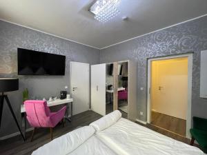 阿尔滕堡Boutiquehotel Mason的一间卧室配有一张床、一张书桌和一台电视。