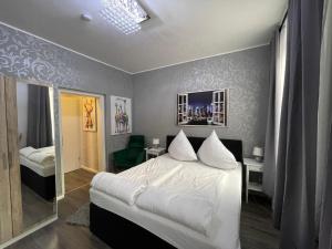 阿尔滕堡Boutiquehotel Mason的卧室配有白色的床和镜子