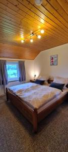 NordledaFerienwohnung mit Pool的卧室内的一张大床,拥有木制天花板