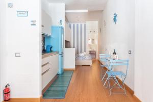 卡利亚里SAILING的厨房配有白色橱柜和蓝色色调