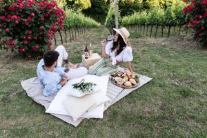 CrecchioBorgo Baccile by Vini Fantini的坐在野餐毯上的女人拍男女的照片