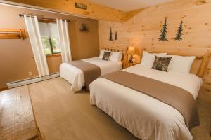 基灵顿下雪旅馆的木墙客房的两张床