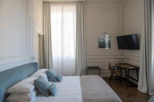 佛罗伦萨Dimora Palanca的一间卧室配有一张带蓝色枕头的床和电视。