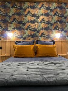 Montigné-le-BrillantDomaine de la Bigottière的一间卧室配有一张带黄色枕头和壁纸的床
