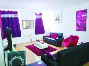 布雷得佛COSY DOUBLE ROOM CLOSE TO UNIVERSITY OF BRADFORD AND CITY CENTRE的客厅配有紫色家具和电视