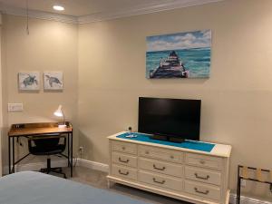 马可岛Paradise Found - Private Oasis with Heated Pool on Marco Island的一间卧室配有带电视和书桌的梳妆台。