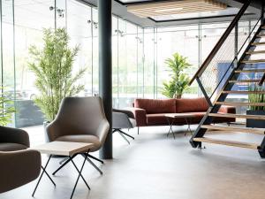 霍夫多普Executive Residency by Best Western Amsterdam Airport的一个带沙发和椅子的大堂和一个楼梯