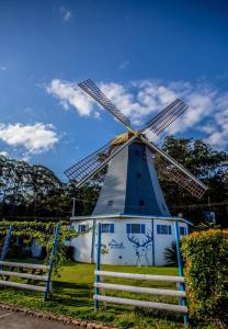 科夫斯港Coffs Windmill Motel的蓝色和白色的风车,四周有栅栏