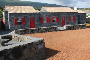圣罗克杜皮库阿德加杜米兰特度假屋的一座红色门和石墙的建筑