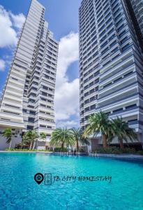 新山米日德恩米迪尼@JB市民宿的两座高大的建筑,在游泳池前种有棕榈树
