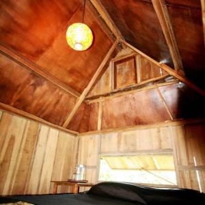 塞莱马德加巴厘岛芒廷山林小屋的一间设有木制天花板和窗户的客房