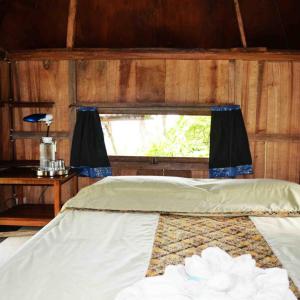 塞莱马德加巴厘岛芒廷山林小屋的窗户客房内的一张床位
