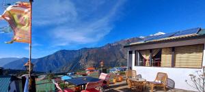 LuklaLama Hotel - Cafe De Himalaya的阳台配有桌椅,享有山景。