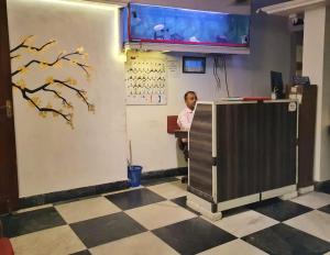 加尔各答格鲁吉亚酒店的站在办公室柜台后面的人