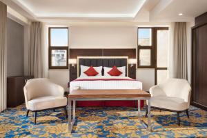 埃里温Ramada Hotel & Suites by Wyndham Yerevan的酒店客房,配有一张床和两把椅子