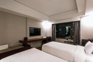 首尔Seoul Garden Hotel的酒店客房设有两张床和电视。