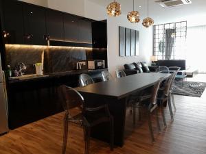 怡保Palm Suite Ipoh Octagon的一间用餐室,配有黑色的桌子和椅子