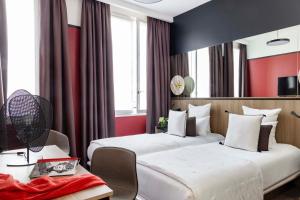 巴黎Hôtel Opéra Liège的红色墙壁的酒店客房内的两张床