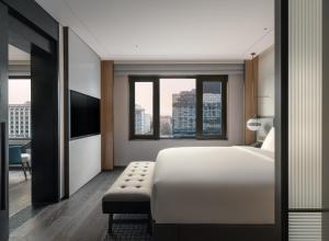 北京北京华侨大厦睿世酒店的卧室设有白色的床和大窗户