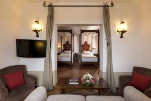 托尔托萨托尔托萨旅馆的一间带两张床和电视的客厅