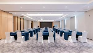 重庆重庆观音桥假日酒店的一间会议室,配有蓝色的桌子和白色的椅子