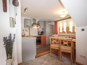 索尔登Apartment Beim Holzschnitzer-1 by Interhome的带桌椅的厨房和带吧台的厨房
