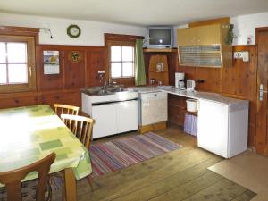 图克斯Chalet Lippnerhütte - LNH120 by Interhome的一间厨房,配有白色家电和桌椅