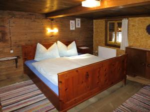 图克斯Chalet Lippnerhütte - LNH120 by Interhome的卧室配有带白色枕头的大型木质床。