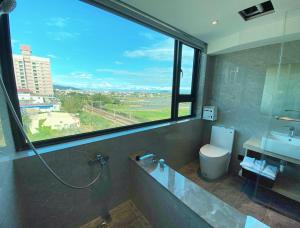 礁溪Love Tong的浴室设有窗户、水槽和卫生间。