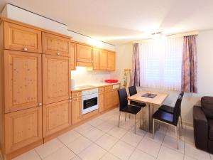 采尔马特Apartment Roger-2 by Interhome的厨房配有木制橱柜和桌椅