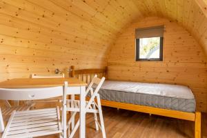 卡兰斯拓克Camping Pods Trevella Holiday Park的小屋内带床和桌子的房间