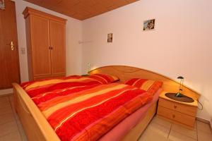 滨湖克拉科Ferienhaus Krakow am See SEE 4001的一间卧室配有一张带红色和橙色毯子的床