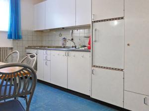 采尔马特Apartment Dianthus-1 by Interhome的厨房配有白色橱柜和冰箱。