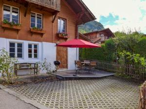 BrienzwilerChalet Hüsli by Interhome的一个带桌子和红色遮阳伞的庭院