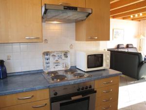 多鲁姆纽菲尔德Holiday Home Cuxland Ferienpark-1 by Interhome的厨房配有炉灶和微波炉。