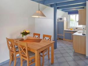 多鲁姆纽菲尔德Holiday Home Cuxland Ferienpark-1 by Interhome的厨房配有木制餐桌和椅子
