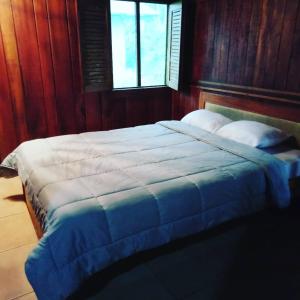 图里亚尔瓦Pochotel的一间卧室配有一张带木墙的大床