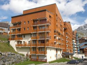 葱仁谷Apartment Les Lauzières-10 by Interhome的旁边设有木制阳台的建筑