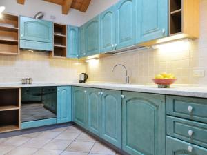 坎皮泰洛Apartment Ardoney-2 by Interhome的厨房配有蓝色橱柜和水槽