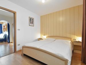 坎皮泰洛Apartment Lazzer-2 by Interhome的一间卧室配有一张大床和镜子