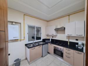突尼斯Appartement Elyssa的厨房配有白色橱柜和水槽