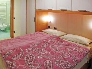 坎皮泰洛Apartment Giovanni - CPO359 by Interhome的一间卧室配有一张带红色毯子的床