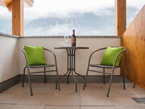 佩特诺伊阿尔贝格Apartment Bella Monte-2 by Interhome的一张桌子、两把椅子和一瓶葡萄酒