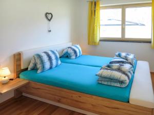 齐勒谷地施特拉斯Apartment Zillertalblick - FGZ230 by Interhome的客房内的蓝色沙发上配有枕头