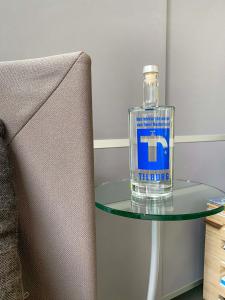 蒂尔堡冬季住宿加早餐旅馆的沙发旁玻璃桌上的一瓶水