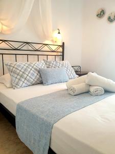 普拉提伊亚洛斯西弗诺斯Sifnos Hotel Benaki的卧室内的两张床、毛巾和枕头
